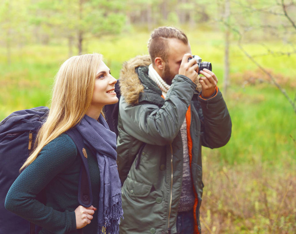 couple walking in forest and taking pictures - Fotografie, Obrázek