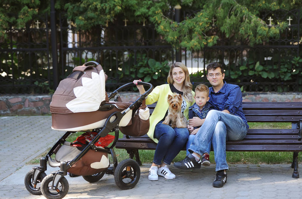 Happy family sit in the autumn park on a bench - Foto, imagen