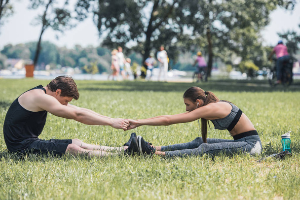 couple stretching in park - Valokuva, kuva