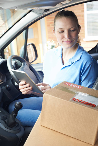 Female Courier In Van Delivering Package To House - 写真・画像
