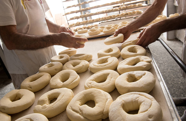 Panaderos preparando masa para rosquillas
 - Foto, Imagen