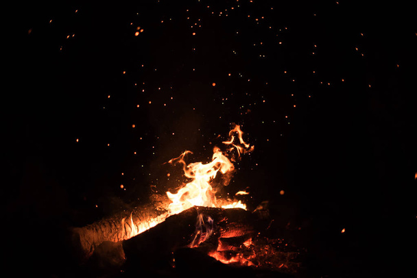 Background of orange and red sparks from a campfire at night - Photo, Image