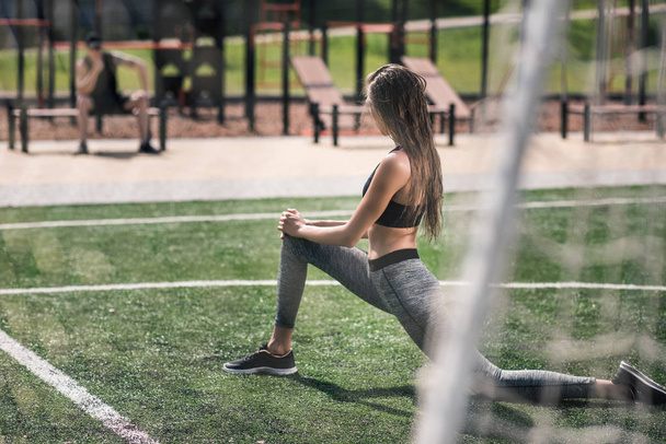 woman stretching on sports field - Foto, Bild