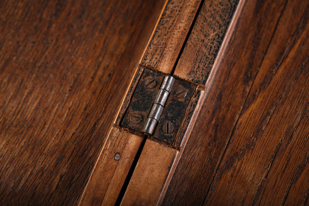 Door hinges against a wooden background. Rusty iron details on a dark wooden background. - Photo, Image