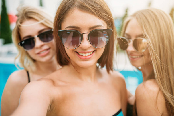 three happy young women at poolside - 写真・画像