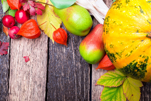 Thanksgiving background with autumn fruits and gourds on a rustic wooden table. Autumn harvest. Top view. Copy space. Thanksgiving frame - Photo, Image