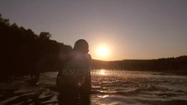 girl at sunset playing in water, girl hands splashing water - Footage, Video