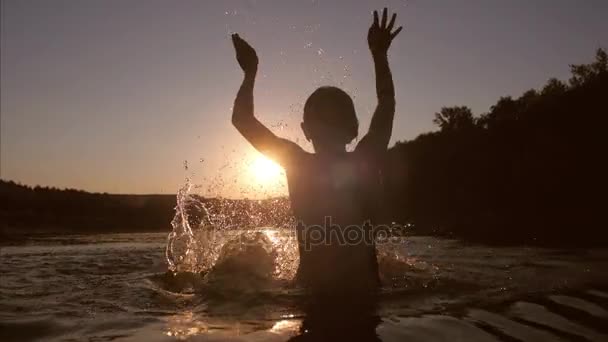 menina ao pôr do sol jogando na água, as mãos da menina salpicando água, câmera lenta, câmera lenta
 - Filmagem, Vídeo