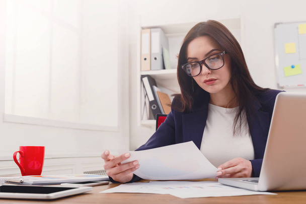 Business woman reading document at office desktop - Фото, изображение