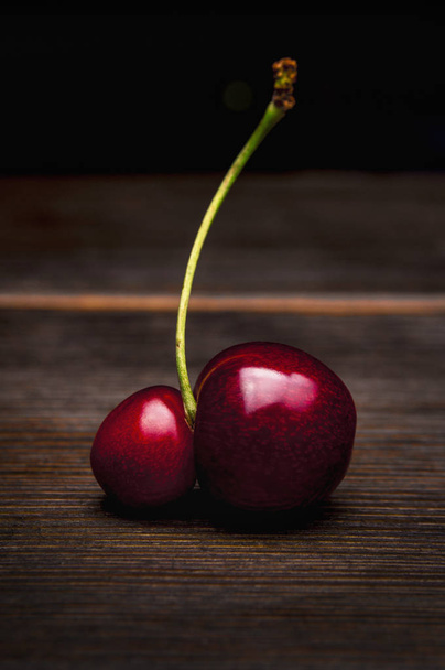Single ripe cherry on wooden background - Photo, Image