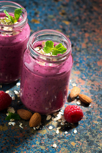 healthy berry smoothie in a bottle on a dark background, closeup - Foto, afbeelding