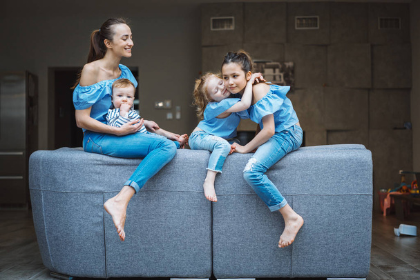 Mom, two daughters and a little son on the couch - Valokuva, kuva