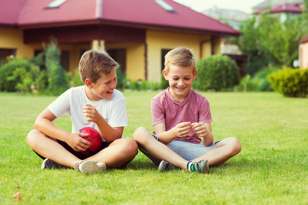 Two boys having fun during playing football in schoolyard - Fotó, kép
