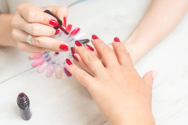 The manicurist paints the nails of women - Photo, Image