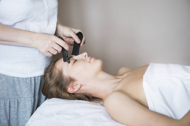 Mujer joven tiene tratamiento facial en clínica de belleza - Foto, Imagen