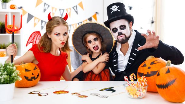 familia feliz en disfraces preparándose para Halloween en hom
 - Foto, Imagen