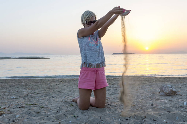 blond woman plays with the sand - Foto, imagen