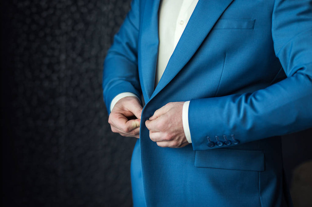 El hombre de negocios lleva una chaqueta. Político, estilo del hombre, primer plano de las manos masculinas, americano, empresario europeo, concepto de negocio, moda y ropa
 - Foto, Imagen