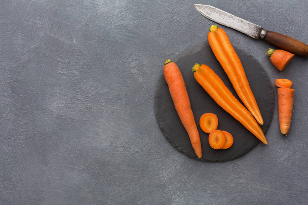 Rustic slate stone plate with carrots, copy space - Фото, изображение