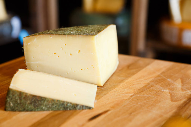 Жорсткий сир як шматки на дерев'яному столі крупним планом
 - Фото, зображення