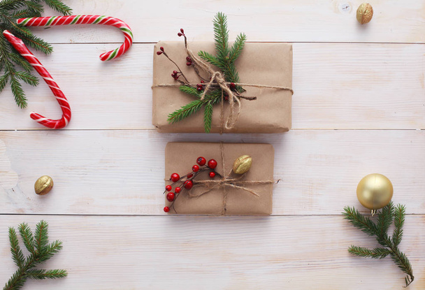 Christmas gift boxes and fir tree branch on wooden table, flat lay - Foto, Imagem