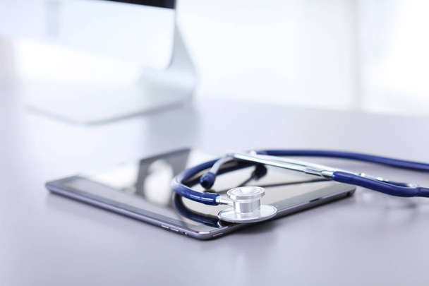 Equipo médico: estetoscopio azul y tableta sobre fondo blanco
 - Foto, Imagen