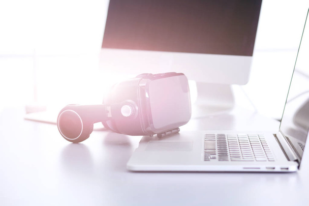 Virtual reality goggles on desk with laptop - Valokuva, kuva