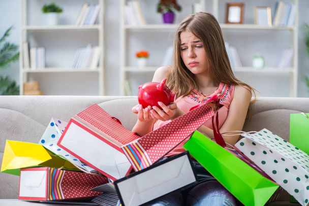 Młoda kobieta z torbami na zakupy w domu na kanapie - Zdjęcie, obraz