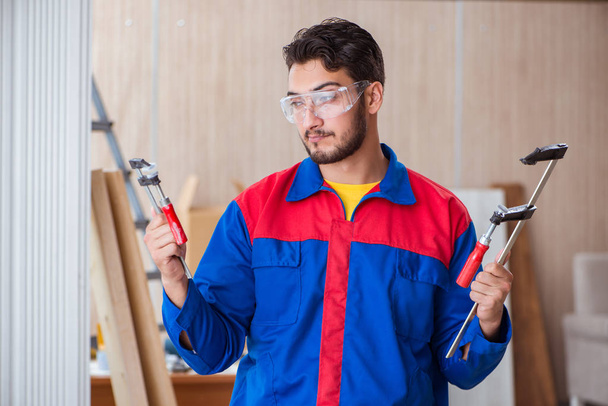Joven carpintero reparador trabajando con abrazaderas - Foto, imagen