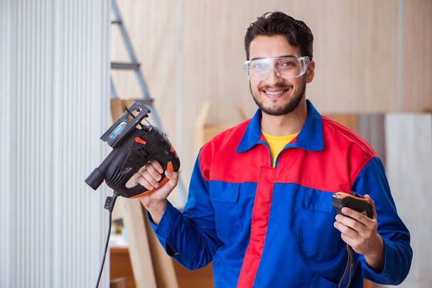 Jovem reparador trabalhando com uma serra elétrica - Foto, Imagem