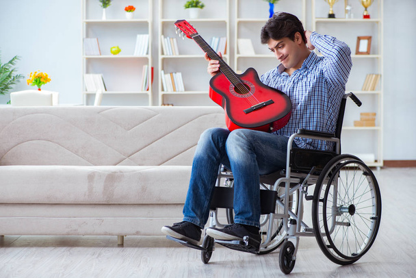 Niepełnosprawny gra na gitarze w domu - Zdjęcie, obraz