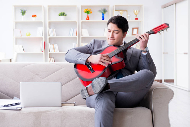 Επιχειρηματίας παίζει κιθάρα στο σπίτι - Φωτογραφία, εικόνα