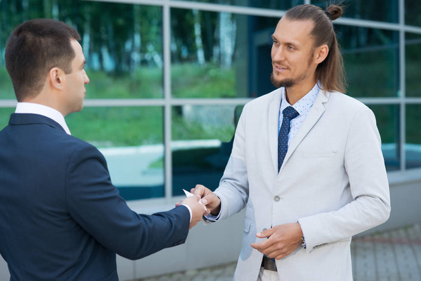 бизнесмен встретил своего партнера, мужчина пожал руку другому мужчине и улыбнулся
 - Фото, изображение