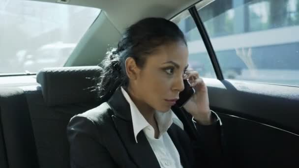 Zakenvrouw op de achterbank van de auto, praten over de telefoon, roddelen met vriend - Video