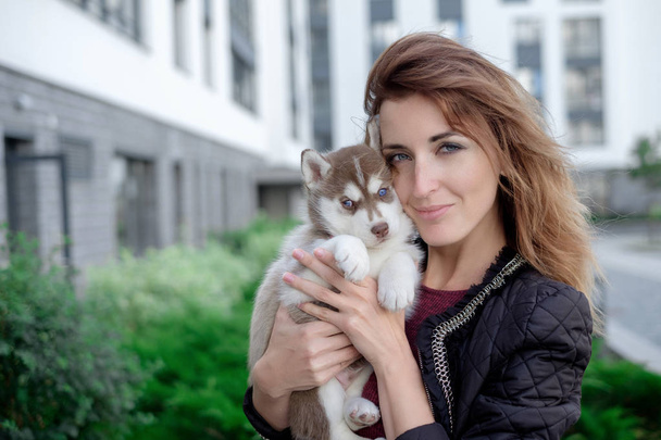 Smiling woman holding cute husky puppy - Foto, immagini