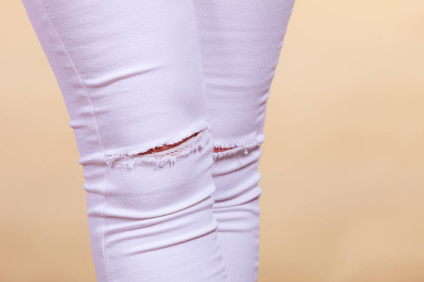 Closeup of white trousers with holes on knees - Foto, Imagem