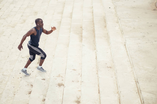 male african athlete running up flight of stairs with speed - Φωτογραφία, εικόνα