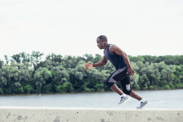Healthy young athletic man running at the road - 写真・画像