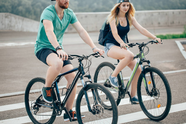 Attractive couple on a bike ride on a sunny day in the city - Photo, Image