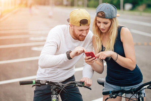 Couple on bike looking phone. Man and woman in road trip using mobile phone. - 写真・画像