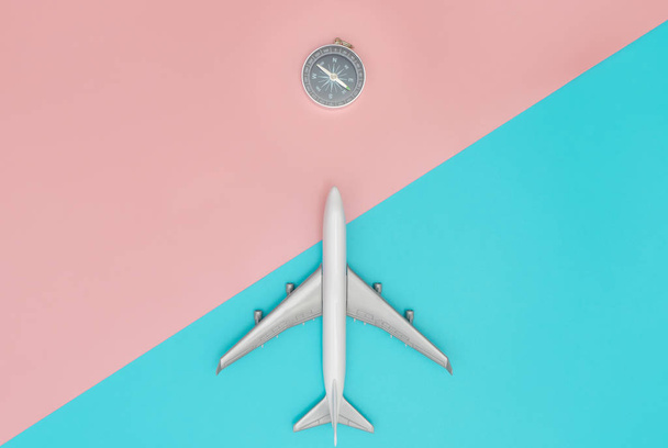 Pusula yönü ile pastel arka plan üzerinde uçan oyuncak uçak - Fotoğraf, Görsel
