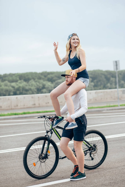 couple biking in park, smiling and girlfriend on shoulder - Foto, Imagem