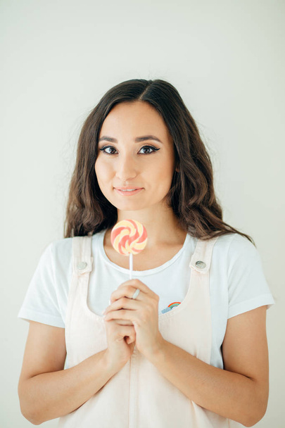 Beautiful sexy woman model with pink lips and lollipop on white background - Φωτογραφία, εικόνα