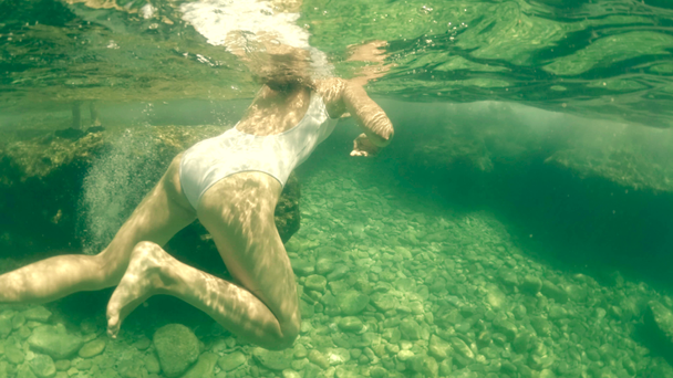 Όμορφη νεαρή γυναίκα σε λευκό μαγιό κολύμβησης στη θάλασσα, υποβρύχιο πυροβολισμό - Πλάνα, βίντεο