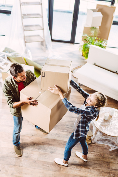 couple with cardboard boxes in new house - Photo, Image