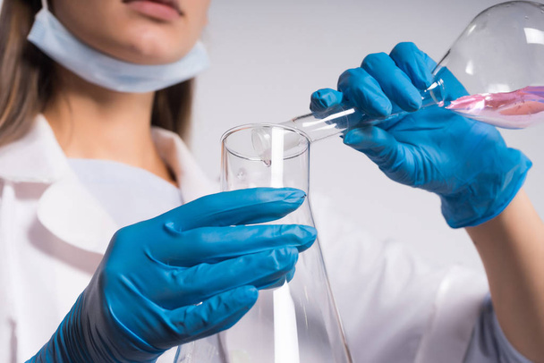 A young woman scientist is mixing a liquid - Φωτογραφία, εικόνα