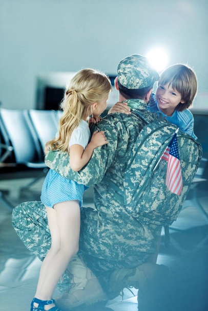 kids hugging father at airport - Фото, зображення