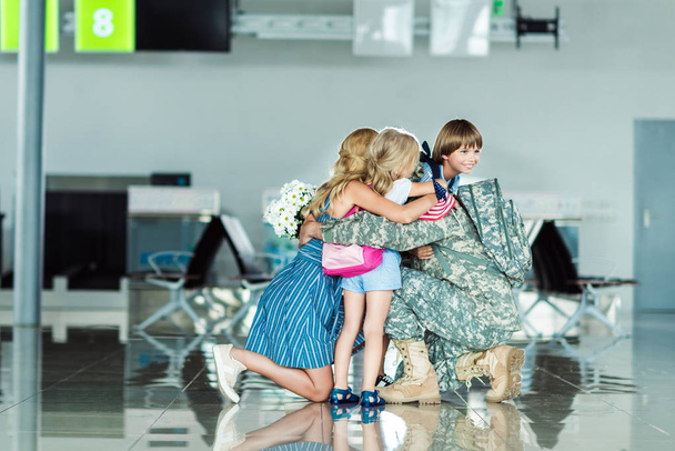 family hugging father at airport - Foto, afbeelding