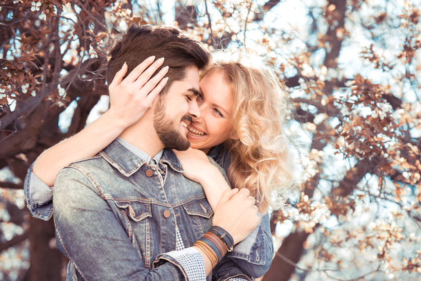 happy couple in blooming park - Foto, Imagen