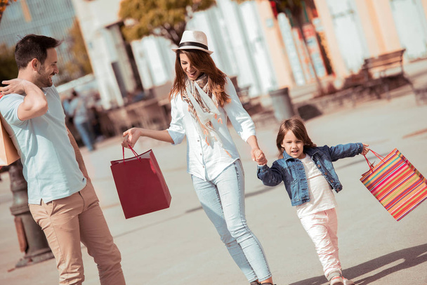 Family with shopping bags on street. - Photo, Image
